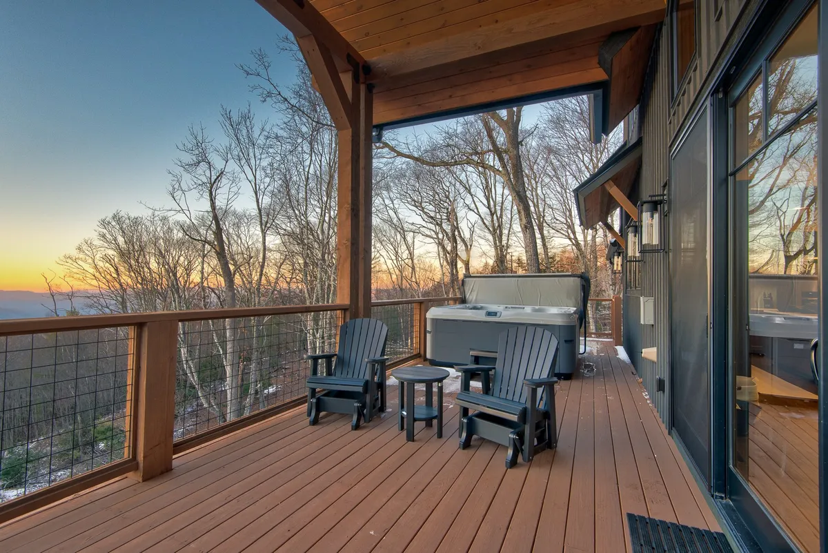 An inviting outdoor space featuring a hot tub and comfortable seating area, perfectly positioned for enjoying a colorful mountain sunset. The mood is tranquil, encouraging relaxation and socializing after an active day outdoors.